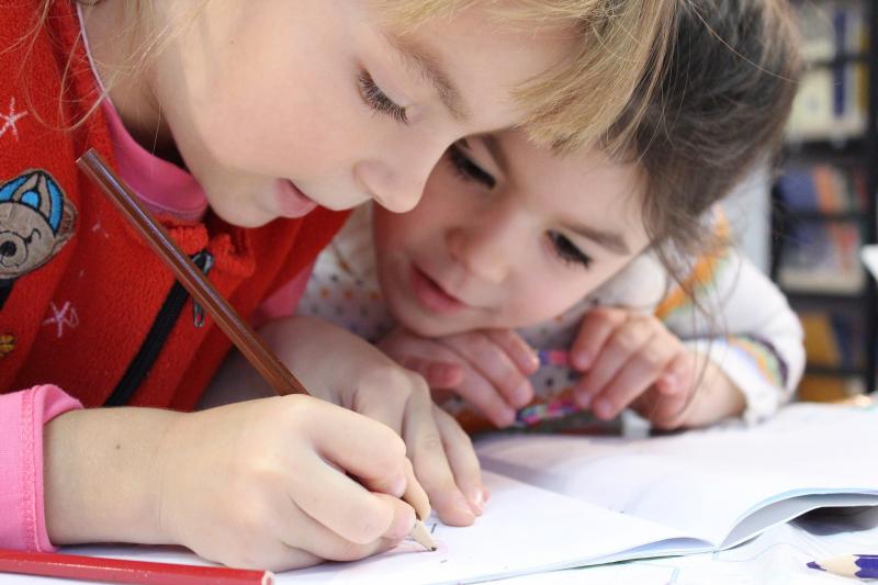 BECSENGETTEK MINDENKINEK!: Illusztratív fotó két kisiskolás gyermekről, amint a füzetükbe rajzolnak