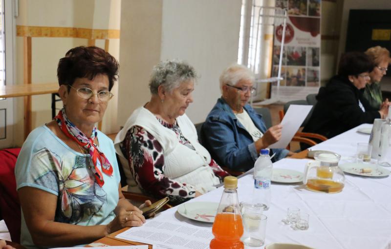 ’56-RA EMLÉKEZÜNK: Vendégváró asztalnál helyet foglaló érdeklődők a Macsi Nyugdíjasklub együttműködésével szervezett programon